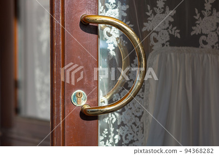 Door handle at the entrance to the restaurant, gold Door handle at the entrance to the restaurant, gold 94368282