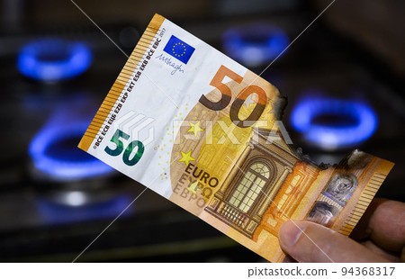 Euro money and gas burners, burnt EU banknote near gas stove 94368317