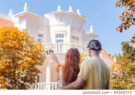 Visit to museum. Young couple of man and woman with tattoos huge on the street and look at beautiful white house. Back view. The concept of relationship psychology and purchase of real estate 94368723