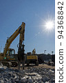 Heavy machinery and shining sun at the demolition site 94368842