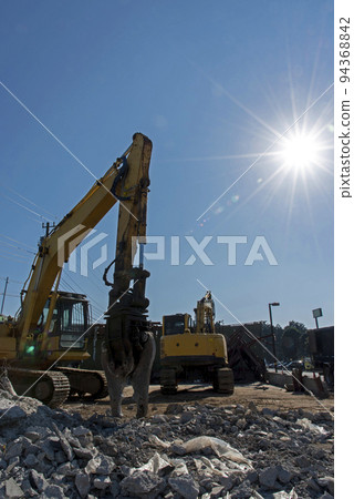 拆除現場的重型機械和燦爛的陽光 94368842