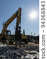 Heavy machinery and shining sun at the demolition site 94368843