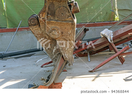 Small demolition machine that grabs steel scraps at the demolition site Small demolition machine that grabs steel scraps at the demolition site 94368844