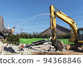 A demolition site where water is sprayed to reduce dust 94368846