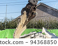 A demolition machine that lifts a demolished concrete slab 94368850