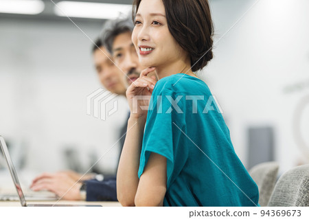 Career woman listening at a meeting Career woman listening at a meeting 94369673