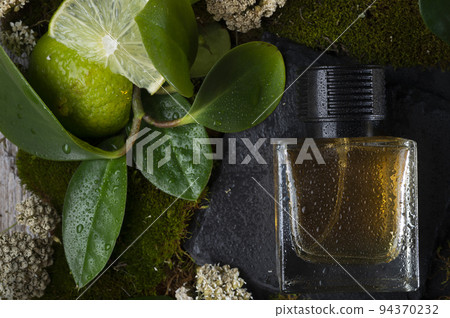 perfume bottles around green moss, flowers , leaves and lime . close up. perfumery concept perfume bottles around green moss, flowers , leaves and lime . close up. perfumery concept 94370232