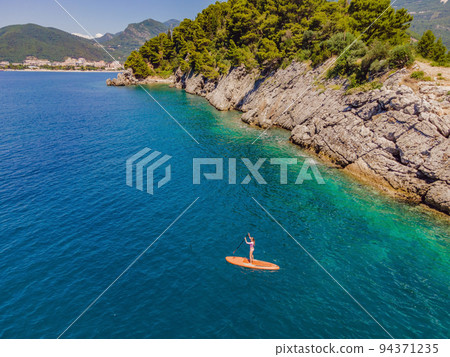 Young women Having Fun Stand Up Paddling in blue water sea in Montenegro. SUP. girl Training on Paddle Board near the rocks Portrait of a disgruntled girl sitting at a cafe table 94371235