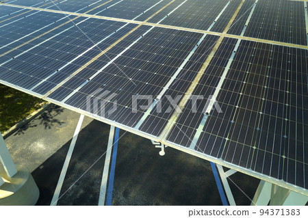 Solar panels installed over parking lot for parked cars for effective generation of clean energy Solar panels installed over parking lot for parked cars for effective generation of clean energy 94371383