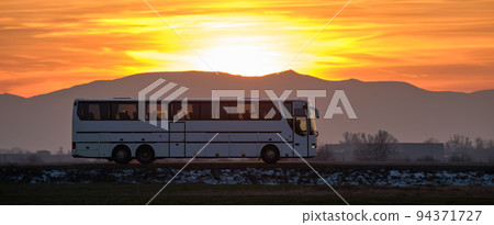 Intercity passenger bus driving on highway road in evening 94371727