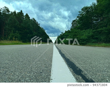 Asphalt empty highway with dividing strip. Road with view of rain clouds Asphalt empty highway with dividing strip. Road with view of rain clouds 94371804