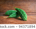 Wild bitter gourd on a wooden background. 94371894