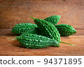Wild bitter gourd on a wooden background. 94371895