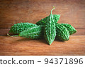 Wild bitter gourd on a wooden background. 94371896