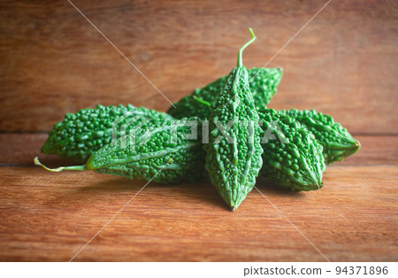 Wild bitter gourd on a wooden background. 94371896