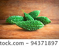 Wild bitter gourd on a wooden background. 94371897