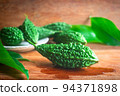 Wild bitter gourd on a wooden background. 94371898