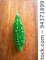 Wild bitter gourd on a wooden background. 94371899