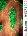 Wild bitter gourd on a wooden background. 94371900