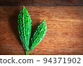 Wild bitter gourd on a wooden background. 94371902