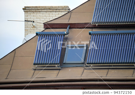Building roof with rows of vacuum air solar collectors for water heating and producing of clean ecological energy. Renewable heat energy with zero emission 94372150