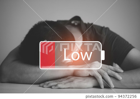 Businessman pressing button Low battery of energy with people icon concept, Saving on working with empty battery symbol,Tired from work and stress concept, Empowering ideas and teamwork 94372256