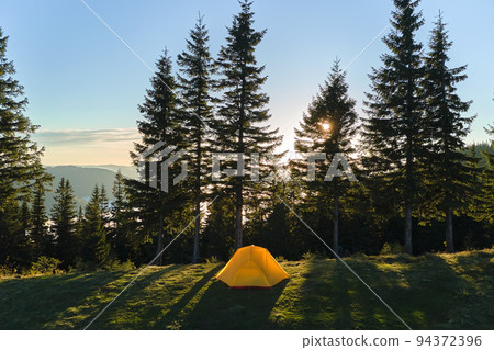 Aerial view of tourist camping tent on mountain campsite at bright sunny evening. Active tourism and hiking concept Aerial view of tourist camping tent on mountain campsite at bright sunny evening. Active tourism and hiking concept 94372396