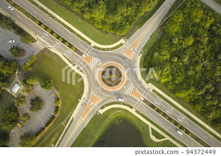 Aerial view of road roundabout intersection with moving cars traffic. Rural circular transportation crossroads 94372449