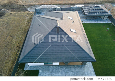 Aerial view of private house with ceramic shingles covered roof top. Investment in real estate concept Aerial view of private house with ceramic shingles covered roof top. Investment in real estate concept 94372480