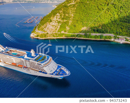 Luxury passenger liner in the bay of Kotor with travel returning after the Covid 19 pandemic Portrait of a disgruntled girl sitting at a cafe table 94373243