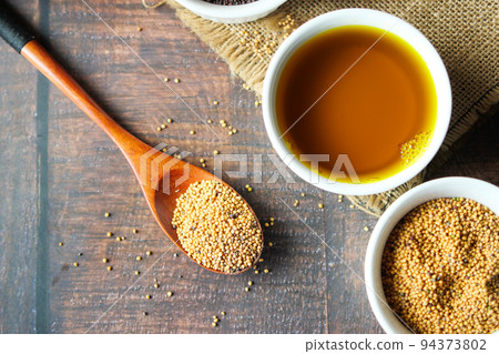 Mustard oil and seed on table top view  94373802