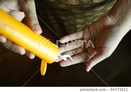 women hand applying sunscreen cream women hand applying sunscreen cream 94373822