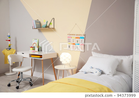 Stylish child room interior with comfortable bed and desk 94373999