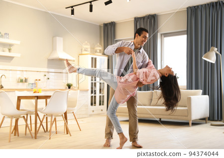 Lovely young interracial couple dancing at home 94374044