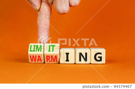 Limiting global warming symbol. Concept words Limiting and Warming on wooden cubes. Businessman hand. Beautiful orange table orange background. Business limiting global warming concept. Copy space. 94374467