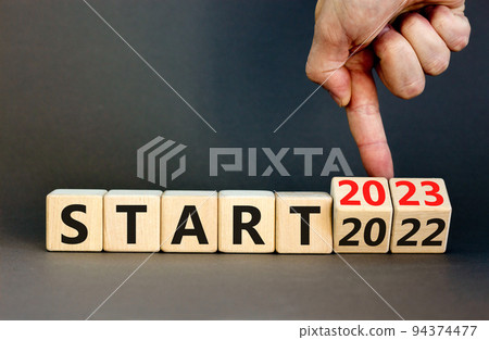 2023 start new year symbol. Businessman turns a wooden cube and changes words Start 2022 to Start 2023. Beautiful grey table grey background, copy space. Business 2023 start new year concept. 2023 start new year symbol. Businessman turns a wooden cube and changes words Start 2022 to Start 2023. Beautiful grey table grey background, copy space. Business 2023 start new year concept. 94374477