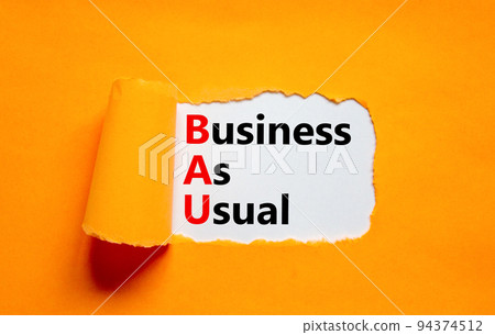 BAU business as usual symbol. Concept words BAU business as usual on white paper on a beautiful orange background. Business and BAU business as usual concept. Copy space. BAU business as usual symbol. Concept words BAU business as usual on white paper on a beautiful orange background. Business and BAU business as usual concept. Copy space. 94374512