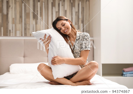 Beautiful woman with soft pillow at home. Bedtime Beautiful woman with soft pillow at home. Bedtime 94374867