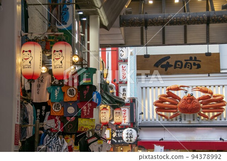 Osaka Sennichimae shopping street lined with shops displaying crab signs and T-shirts 94378992