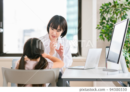 Female pediatrician examining a girl Female pediatrician examining a girl 94380330