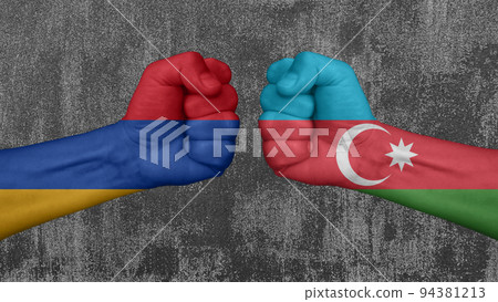 Armenia versus Azerbaijan, two fists, with national flags, collide. In the background a ruined wall Armenia versus Azerbaijan, two fists, with national flags, collide. In the background a ruined wall 94381213