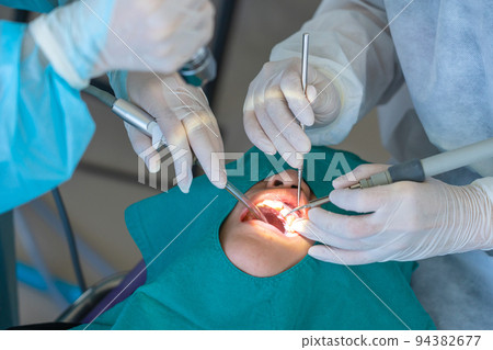doctor cleaning the teeth patient with ultrasonic tool doctor cleaning the teeth patient with ultrasonic tool 94382677