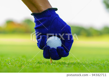 Hand Golfer hold Golf ball with tee ready to be shot at golf court 94382711
