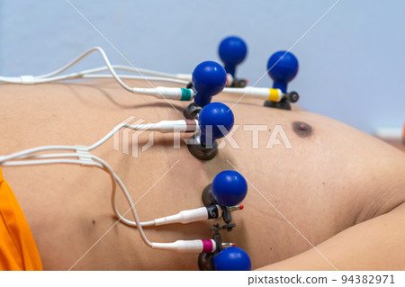 ECG or EKG of man with electrodes for electrocardiogram records on bed in hospital 94382971