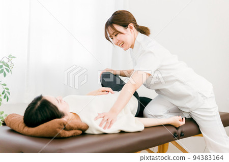 A manipulative woman massaging a patient A manipulative woman massaging a patient 94383164