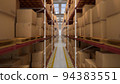 Warehouse hall with boxes and orders. Industrial interior of the hall with lighting. Logistics distribution industrial interior with gates. The work of the marketplace. Distribution center 94383551