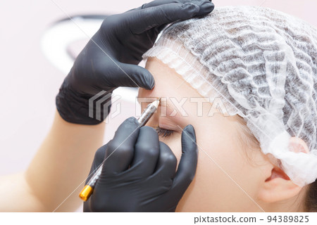 The wizard creates the contour of the clients eyebrows before the procedure. 94389825