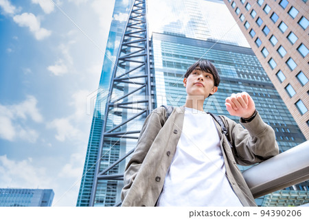 一位身著辦公室便服的年輕商人在新橋站前用手錶看時間 一位身著辦公室便服的年輕商人在新橋站前用手錶看時間 94390206