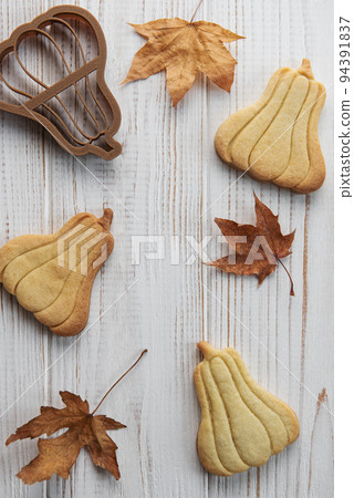 Cookies shaped like pumpkin and leaves on rustic wood background Cookies shaped like pumpkin and leaves on rustic wood background 94391837
