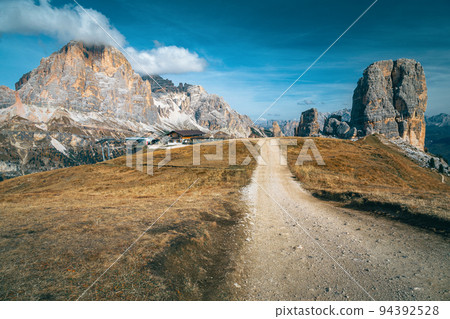 Mountain chalet and Cinque Torri rock formations in the Dolomites 94392528